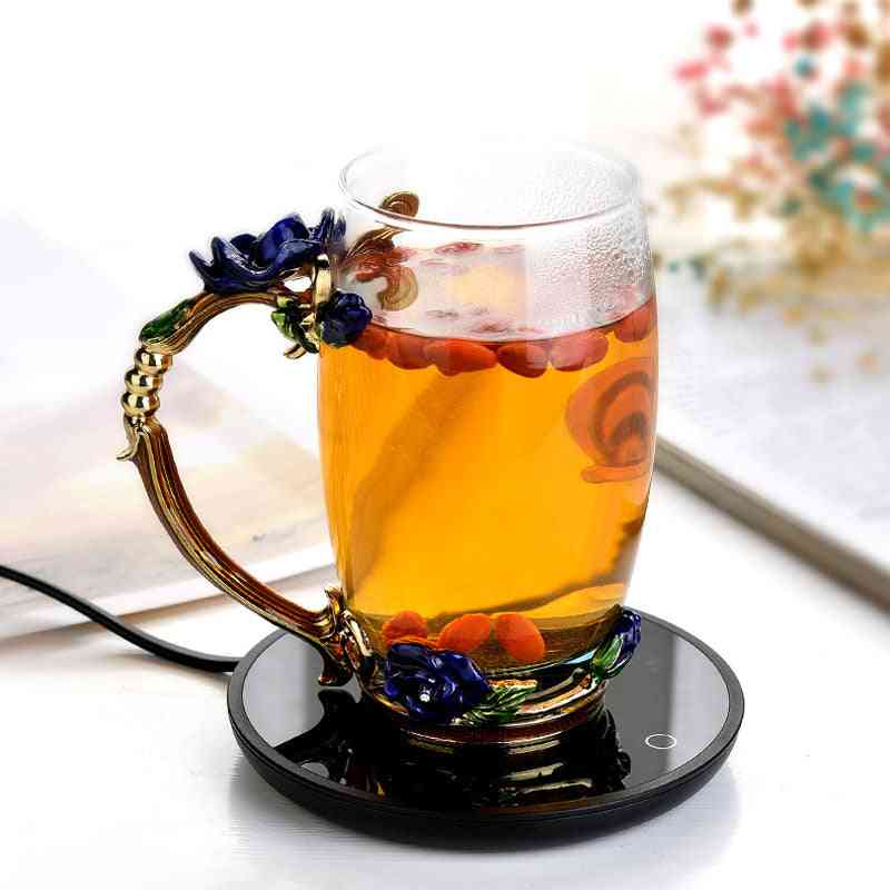 Coffee mug cup warmer heating a glass of tea with floral handle, ideal for home office use to keep milk tea or coffee warm.