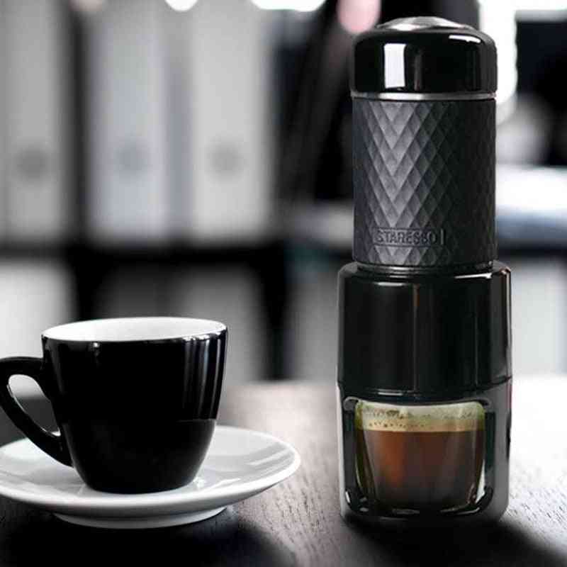 Manual espresso coffee machine in black brewing espresso next to a black cup. Ideal for travel and smart kitchen use.